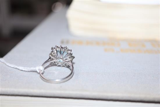 A modern 18ct white metal, aquamarine, baguette and round cut diamond set cluster ring, size K/L.